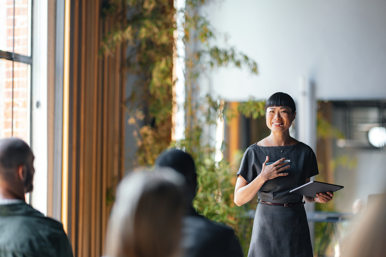 A Business Leader Holding a Tablet Meets With a Group of Business Professionals.