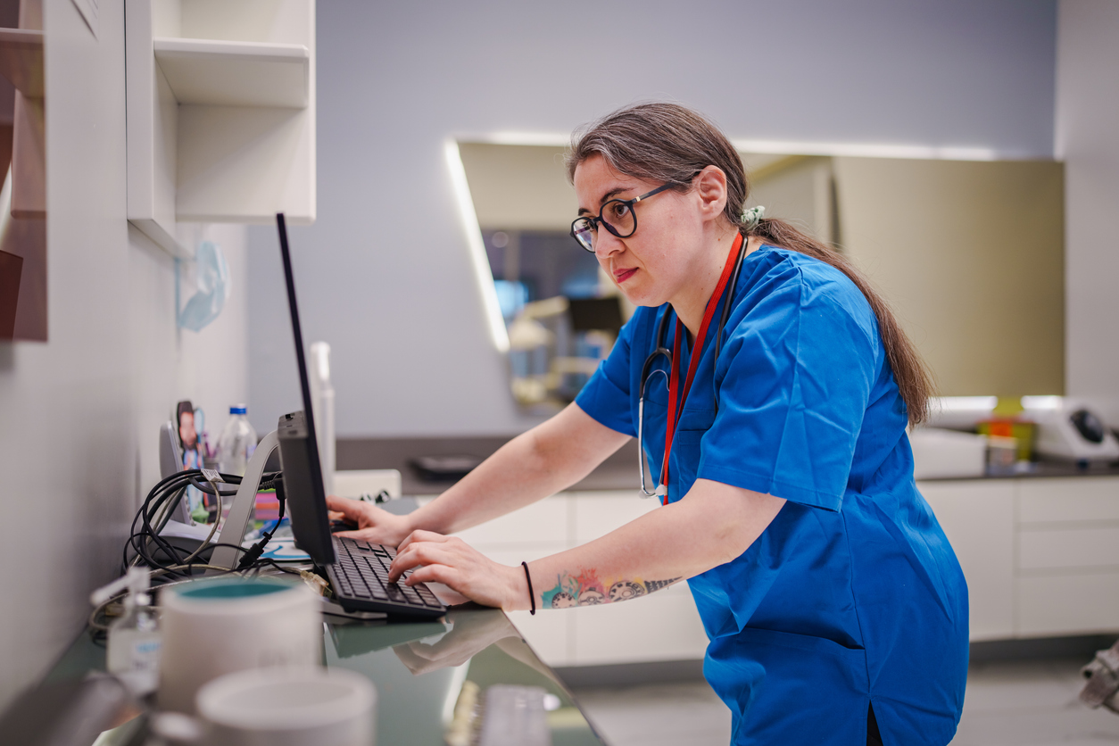 A Nurse Uses a Computer in a Hospital Room..jpg