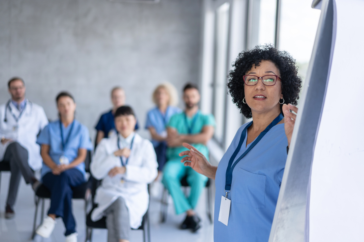 A nurse leads a training session for other nurses and healthcare professionals.
