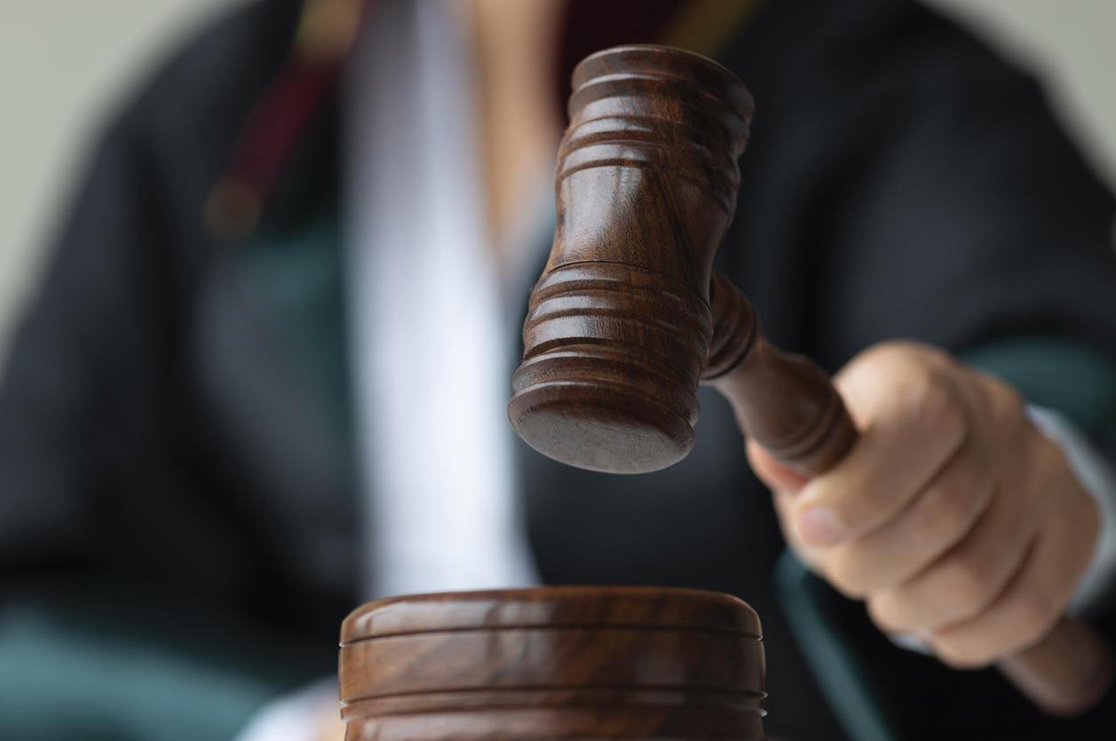 Close up of a judge holding a wooden gavel