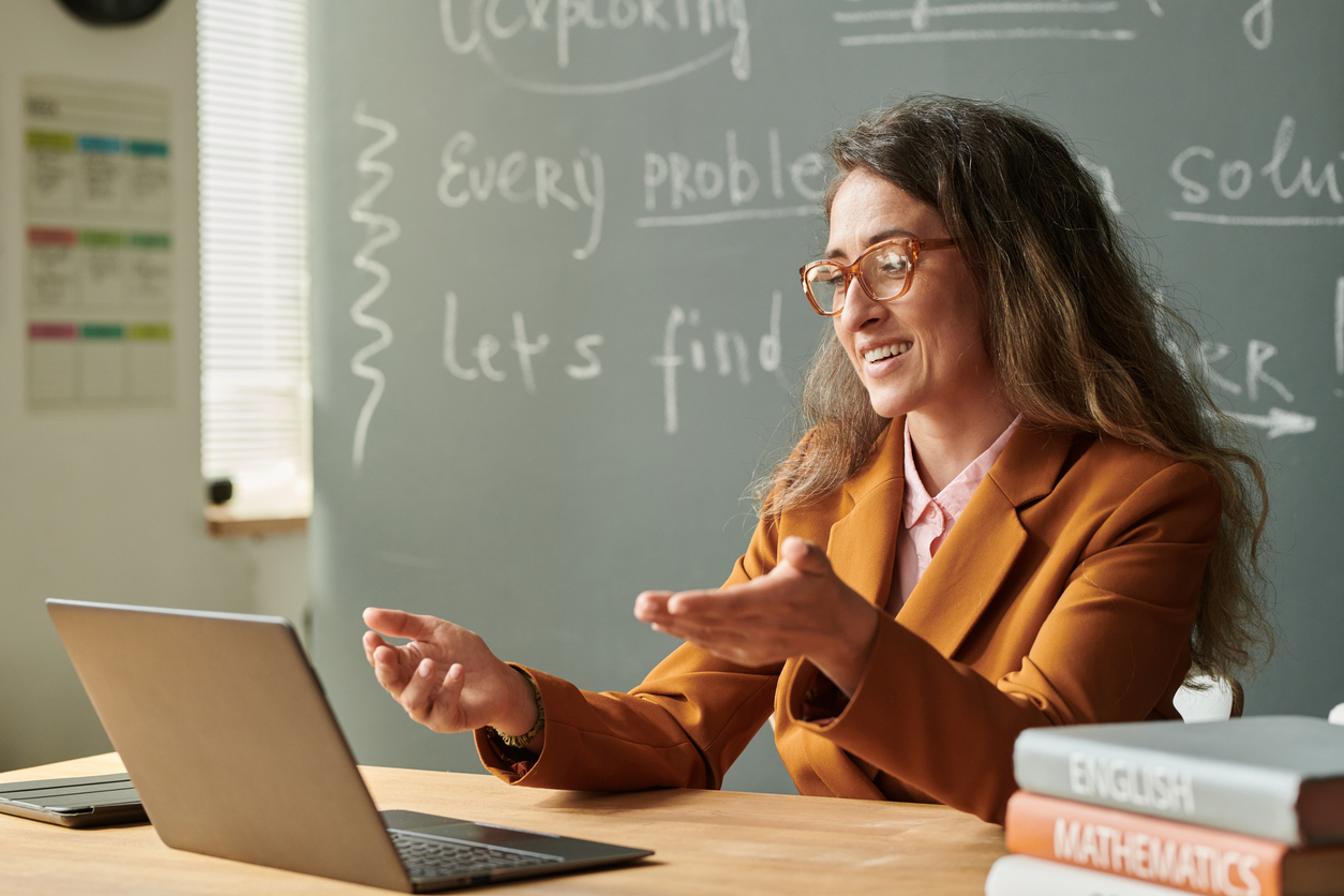 An Online Teacher Leads a Video Class Using a Laptop