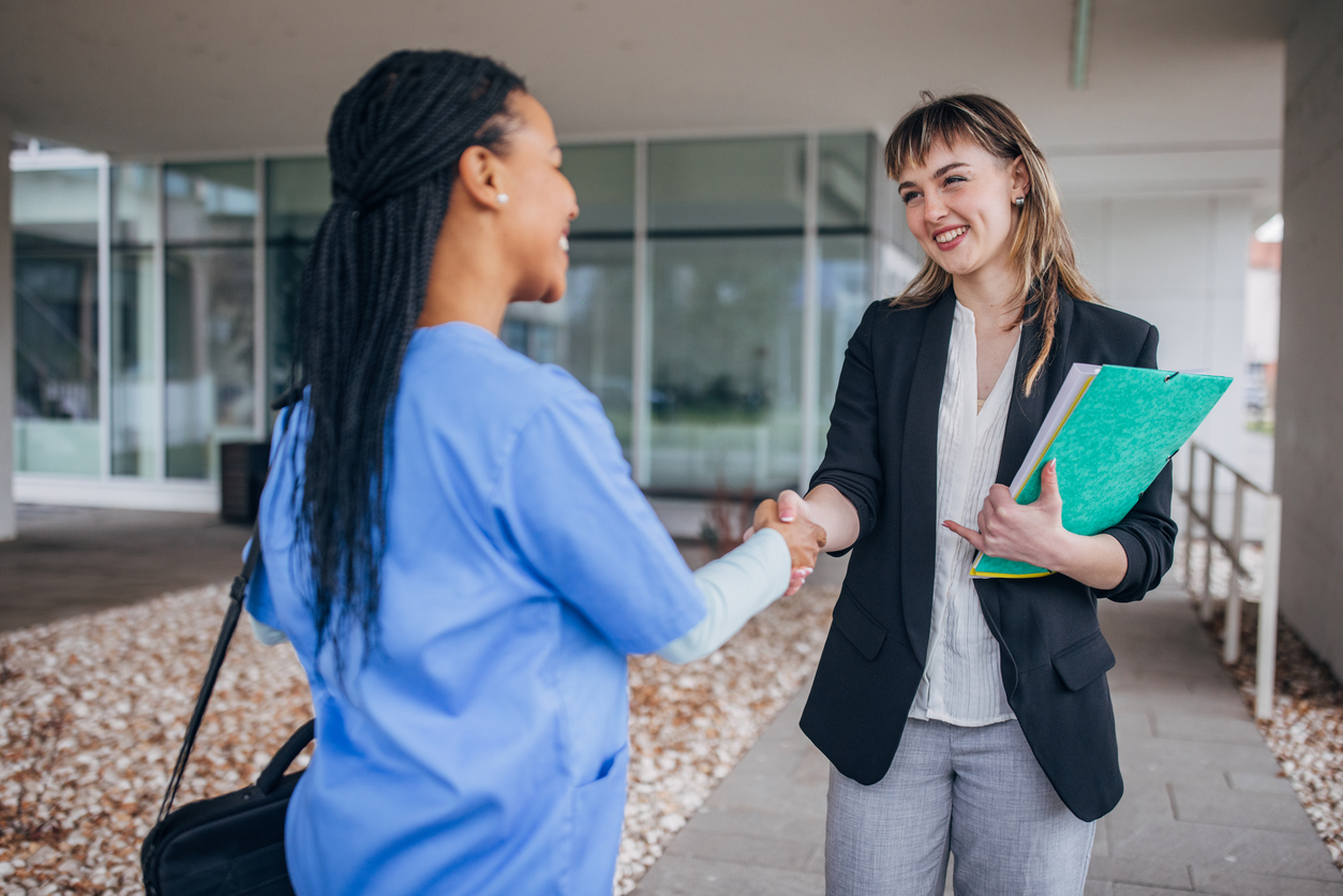 A nurse recruiter shakes hands with a nurse.