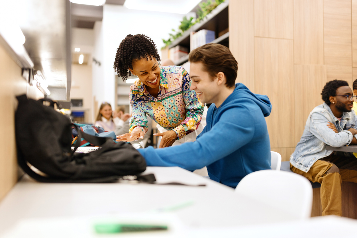 A Smiling Teacher Helps a Student With School Work..jpg