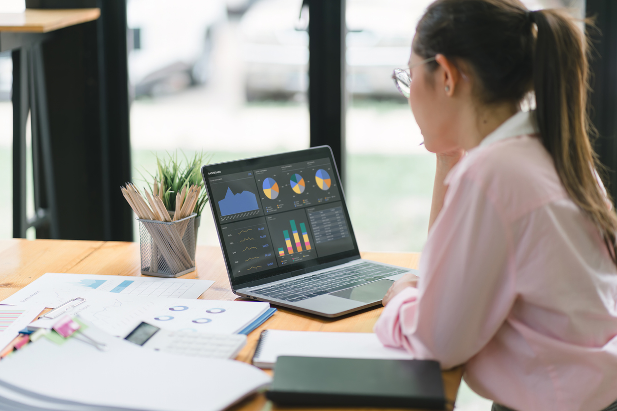 A credit analyst uses a laptop to review financial charts.