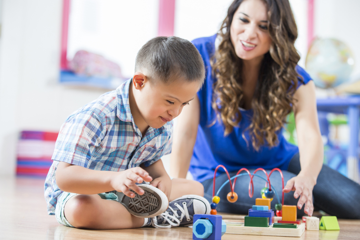 An Early Intervention Specialist Watches a Child Playing With Toys.