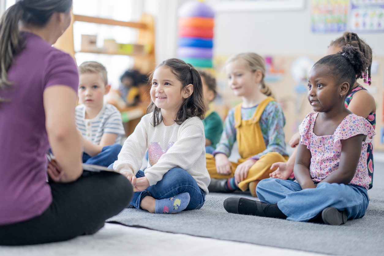 A kindergarten teacher leads a morning meeting.