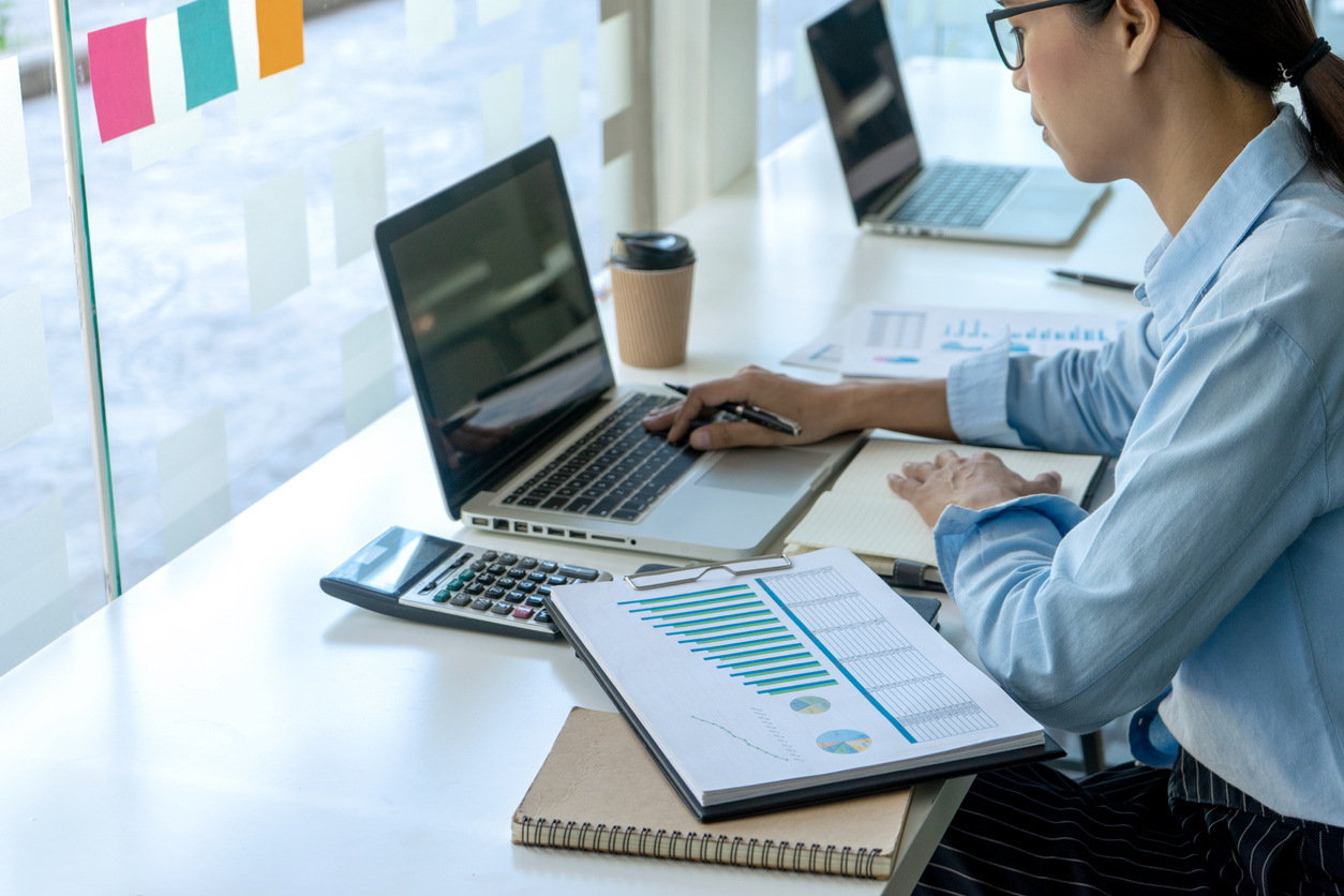 An accountant sitting at a desk and working on a computer.